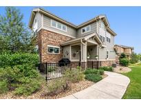 Two-story townhome with stone and siding exterior, patio, and walkway at 1879 S Buchanan Cir, Aurora, CO 80018