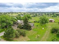 Charming home nestled on a vast, green lot with mature trees and detached garage at 12798 Tomahawk Rd, Parker, CO 80138
