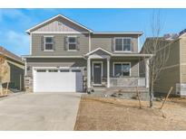 Two-story house with gray siding, white garage door, and a front porch at 14096 Black Sedge Cir, Parker, CO 80134