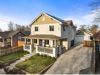 Charming two-story home featuring a welcoming front porch and well-maintained landscaping at 4942 Grove St, Denver, CO 80221