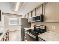 Modern kitchen with stainless steel appliances and ample cabinet space at 8717 Carr Loop, Arvada, CO 80005