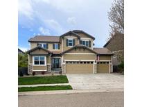 Charming two-story home with a three car garage and landscaped front yard on a sunny day at 420 Graham Cir, Erie, CO 80516
