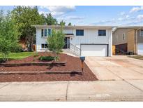 Charming two-story home with white exterior, landscaped yard, and attached two-car garage at 13051 W Jewell Cir, Lakewood, CO 80228