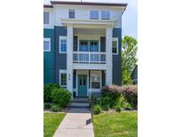 Charming two-story townhome with a covered porch, well-manicured lawn, and lush landscaping at 658 Casper Dr, Lafayette, CO 80026