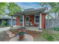 Charming home featuring a cozy front porch with decorative columns and a colorful garden display at 4841 Alcott St, Denver, CO 80221