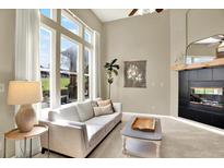 Bright living room with large windows, fireplace, and comfortable seating at 3720 Pecos Trl, Castle Rock, CO 80109