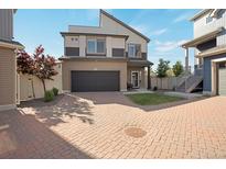 A charming two-story home featuring neutral tones, a black garage door, and a lovely brick driveway at 17838 E 54 Th Ave, Denver, CO 80249