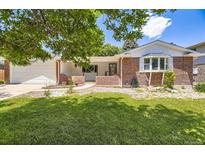 Charming brick home featuring a well-manicured lawn and welcoming entrance at 649 Nucla Way, Aurora, CO 80011