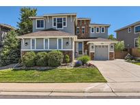 Charming two-story home featuring stone accents, lush landscaping, and a two car garage on a sunny day at 11074 Grayledge Cir, Highlands Ranch, CO 80130