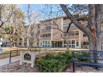 Exterior view of building with landscaped grounds, and a bench out front at 3184 S Heather Gardens Way # 107, Aurora, CO 80014