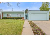 Charming single story home with a manicured lawn and flower beds along the walkway to the front door at 1420 E Bates Ave, Englewood, CO 80113