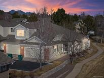 Charming home with a landscaped yard, two-car garage, mountain views at sunset, and sidewalk access at 13535 W 62Nd Ln, Arvada, CO 80004