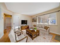 Cozy living room with hardwood floors, area rug, and comfortable seating by a large window at 4157 Perry St, Denver, CO 80212