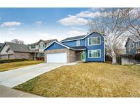 Charming two-story home with blue siding, brick accents, and a well-manicured lawn at 12842 Bellaire St, Thornton, CO 80241