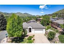 Charming single-story home with mature trees, lush landscaping, and an attached two-car garage at 330 Ptarmigan St, Golden, CO 80403