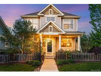 Charming two-story home boasts a welcoming front porch and manicured front yard at 3240 Spruce St, Denver, CO 80238