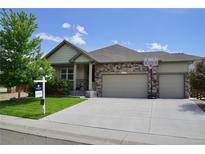 Charming single-Gathering home boasts a stone and vinyl facade, two-car garage, and well-maintained front yard at 22466 E Layton Cir, Aurora, CO 80015