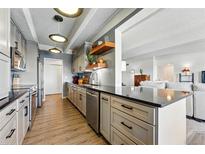 Beautiful updated kitchen with stainless steel appliances, open shelving, and breakfast bar at 7877 E Mississippi Ave # 1008, Denver, CO 80247