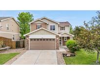 Two-story home featuring a neutral color palette, complemented by a stone-accented garage and a well-manicured front lawn at 13664 Linden Ct, Thornton, CO 80602