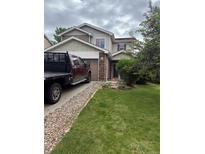 Charming two-story home with a well-maintained lawn, beautiful rock details, and a convenient attached garage at 13664 Linden Ct, Thornton, CO 80602