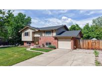 Inviting two-story home with brick accents, attached garage, and well-manicured lawn at 6631 Welch Ct, Arvada, CO 80004