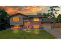 Charming split-level home showcasing a well-maintained lawn, brick accents, and a welcoming entrance at 6631 Welch Ct, Arvada, CO 80004