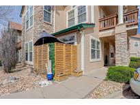 Charming condo featuring stone accents, wood siding, and a cozy, fenced patio area with privacy screen at 3993 S Dillon Way # 104, Aurora, CO 80014