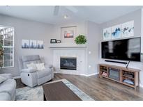 Comfortable living room with a decorative fireplace, modern TV setup, and a cozy gray recliner at 3993 S Dillon Way # 104, Aurora, CO 80014