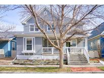 Charming two-story home featuring a welcoming front porch, well-maintained yard, and classic architectural details at 9445 E 106Th Pl, Commerce City, CO 80640