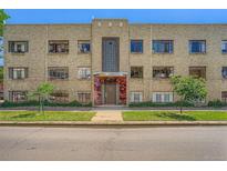 A three-story residential brick building with a distinctive art deco entrance and manicured lawn at 1000 E 8Th Ave # 4, Denver, CO 80218