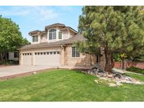 Lovely two-story home featuring a brick and siding facade and a three-car garage with beautifully maintained landscaping at 9432 La Quinta Way, Lone Tree, CO 80124