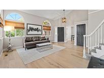 Bright living room features hardwood floors, vaulted ceiling, and large windows with natural light at 9432 La Quinta Way, Lone Tree, CO 80124