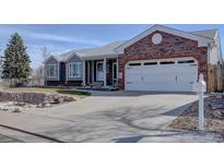 Charming single-Gathering home featuring a brick facade, two-car garage, and well-maintained landscaping at 7160 S Jellison St, Littleton, CO 80128