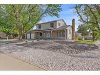 Charming two-story home with a well-maintained lawn, mature trees, and a two-car garage at 18263 E Mansfield Ave, Aurora, CO 80013