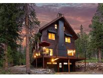 Stunning exterior of a wood-clad home with a deck and well-lit facade against a picturesque sky at 592 Brook Dr, Idaho Springs, CO 80452