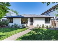 Charming painted brick home with well-manicured lawn and walkway at 1065 S Monroe St, Denver, CO 80209