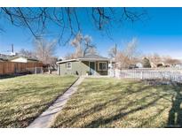 Charming single-story home with a well-manicured lawn and white picket fence at 377 Stuart St, Denver, CO 80219