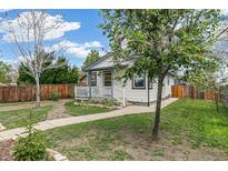 Charming home with a well-maintained front yard and inviting exterior, set beneath a bright blue sky at 2896 Depew St, Wheat Ridge, CO 80214