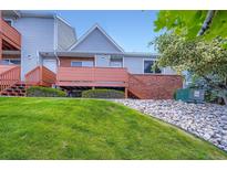 Inviting townhouse featuring a front porch, brick accents, and a well-maintained lawn at 4135 E 119Th Pl # A, Thornton, CO 80233