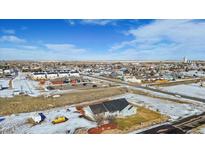 An aerial view of a charming single-Gathering home nestled in a serene neighborhood with clear blue skies above at 51 W 6Th Pl, Byers, CO 80103
