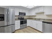 Bright kitchen with white cabinets, granite counters, and stainless steel appliances at 14152 E Linvale Pl # 408, Aurora, CO 80014