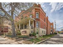 Charming brick apartment building with a covered front porch and mature landscaping in a desirable neighborhood at 1425 N Washington St # 104, Denver, CO 80203