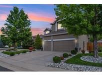 Beautiful two-story home with a two-car garage, well-manicured lawn, and lush landscaping at 18027 E Ida Dr, Centennial, CO 80015