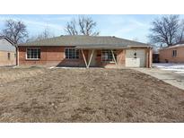 Charming brick home featuring an attached garage and a cozy, covered entryway at 1018 Revere St, Aurora, CO 80011