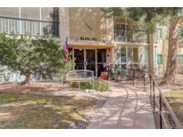 Inviting building entrance featuring an American flag, bench, and accessible ramp at 13635 E Bates Ave # 404, Aurora, CO 80014