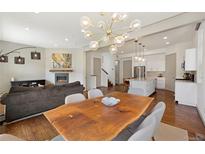 Bright open-concept living space featuring a cozy fireplace and modern lighting fixtures at 4035 Fenton Ct, Wheat Ridge, CO 80212