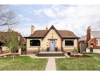 Charming brick home featuring a classic design with a blue front door and a well-maintained front yard at 4828 W 32Nd Ave, Denver, CO 80212
