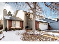 Charming two-story home featuring a brick facade and a well-maintained front yard with a mature tree at 3889 S Fraser St, Aurora, CO 80014