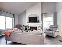 Bright living room features a fireplace with TV mount and large windows for natural light at 3889 S Fraser St, Aurora, CO 80014
