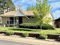 Charming brick home with a well-manicured lawn and a stone retaining wall at 3531 E 91St Ave, Thornton, CO 80229